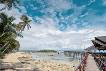 Beautiful landscape. Sunny day on seashore. Wooden bridge on Cloud 9 beach, Siargao Island Philippines.