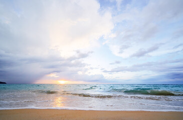 Seascape with sunset on the ocean shore. Beautiful cloudy sky.