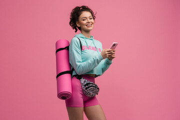 smiling happy beautiful woman in stylish sports outfit posing on pink background isolated in studio