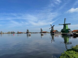 Fototapeta na wymiar Scenic view of windmills reflecting on a lake in Zaandam, Netherlands