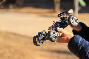 Child playing with a remote-controlled gas-powered toy car