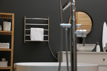 Stylish bathroom interior with heated towel rail and shelving unit