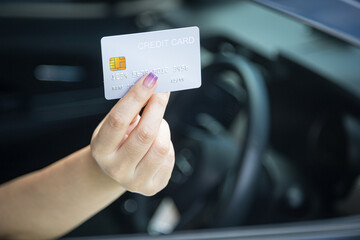 Closed up hand use credit card on car to pay for fuel