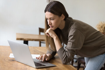 Serious pensive beautiful entrepreneur woman in casual working at office workplace, bending over...