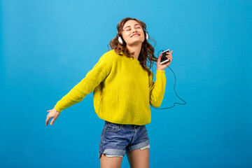 attractive woman in cheerful exited mood listening to music in headphones
