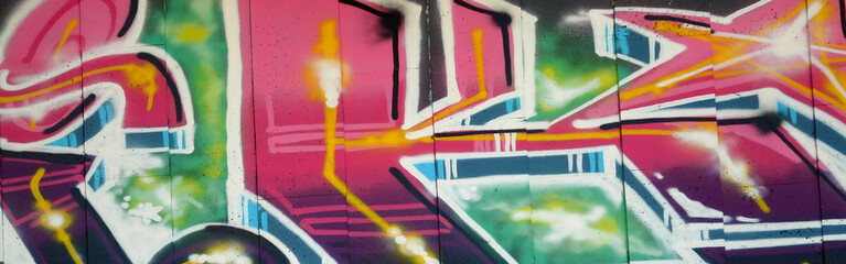 Colorful background of graffiti painting artwork with bright aerosol outlines on wall. Old school street art piece made with aerosol spray paint cans. Contemporary youth culture backdrop