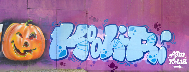 The old wall decorated with paint stains in the style of street art culture. Colorful background of full graffiti painting artwork with bright aerosol outlines on wall. Colored background texture