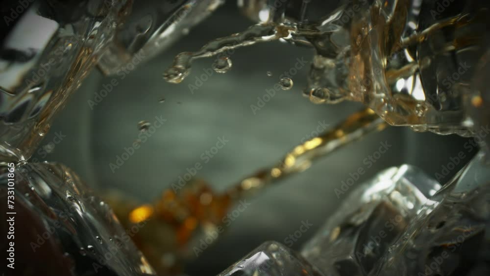 Poster super slow motion of pouring whiskey into glass. unique perspective composition from bottom of the g