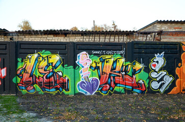 The old wall decorated with paint stains in the style of street art culture. Colorful background of full graffiti painting artwork with bright aerosol outlines on wall. Colored background texture