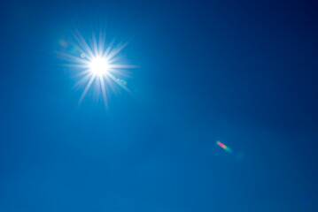Sun, sunbeams against blue sky - cloudless heaven. Photography with Lense flair effect