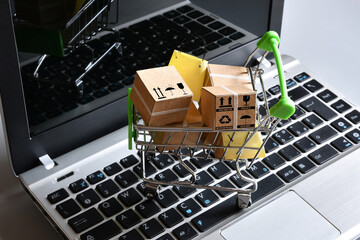 Online shopping. Shopping cart with packages and bags on a laptop keyboard. Concept for online shopping.