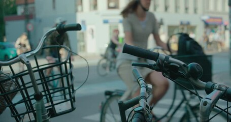 European city busy day concept, bike lane with bicycle commuters on the way home from work or school. Unrecognisable cyclists ride across busy crossing
