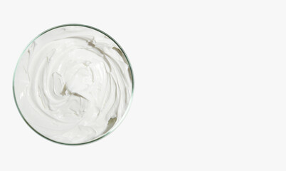 Face and body cream in a round jar or Petri dish. on a light background. View from above