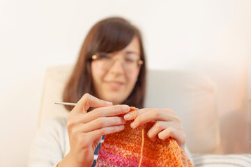 A close-up of the skillful hands of a Caucasian woman knitting wool with a crochet needle. Capturing the art and precision of your craft