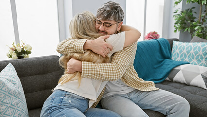 A loving couple embraces warmly in a cozy living room, conveying a sense of love, companionship,...