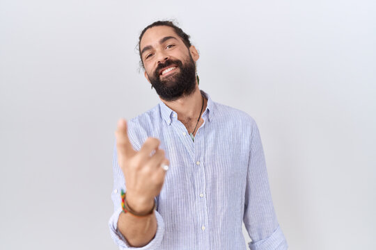 Hispanic man with beard wearing casual shirt beckoning come here gesture with hand inviting welcoming happy and smiling
