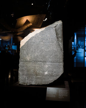 London, UK - December 10 2022 : Close up detail of the Rosetta Stone in the briths museum. This fragment of an ancient stela (an inscribed slab), most famous rock in world. 