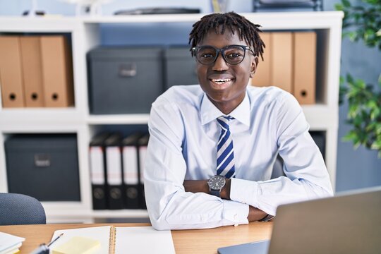 African american man business worker smiling confident sitting with arms crossed gesture at office