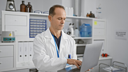 Serious middle age man, a devoted scientist engrossed in groundbreaking research using tech-savvy laptop, engrossed in a medical experiment at the bustling lab.