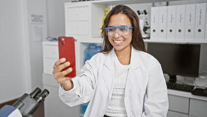 Radiant young hispanic woman scientist, beautifully working on her latest breakthrough in the lab,...