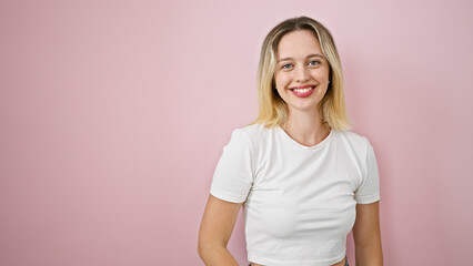 Fototapeta premium Young blonde woman smiling confident standing over isolated pink background