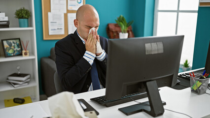 Young hispanic man business worker using computer sneezing at the office