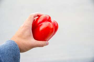 man hand holding red pepper on blured background