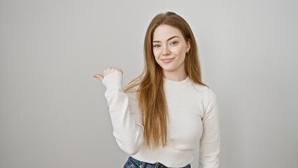 A young adult caucasian woman with blonde hair in a white sweater gestures with her thumb against...