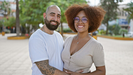 Beautiful couple, full of joy and positivity, hugging and sharing a sunny laugh in an outdoor park. casual, fun love, their confident smiles radiating happiness.