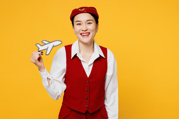 Young smiling happy stewardess flight attendant woman of Asian ethnicity wear red vest shirt hat...