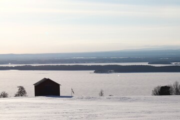 View of the mountains, meadows and the lake. Trees and mountains in winter. Winter landscape in Östersund.

