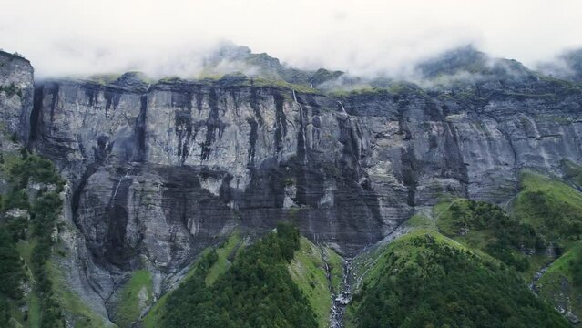 Giffre valley of mountain range with cascade and foggy in French Alps borderland at France