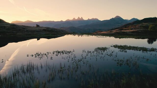 Sunrise shines over Lac Guichard with Arves massif and lake reflection in autumn at Aiguilles d'Arves, French Alps, France