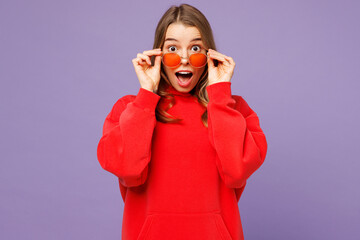 Young surprised overjoyed blonde woman she wear red hoody casual clothes lower sunglasses look...