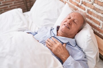 Middle age grey-haired man lying on bed sleeping at bedroom