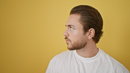 Obraz premium Young hispanic man looking to the side with serious expression over isolated yellow background