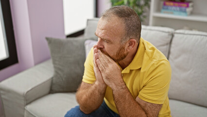 Caucasian man stressed sitting on sofa at home