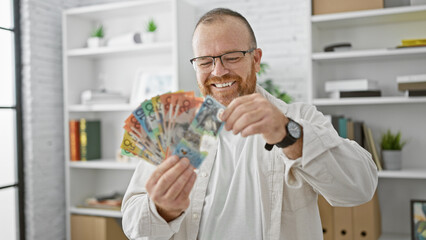Cheerful caucasian business man confidently counting australian dollars at office, radiating...