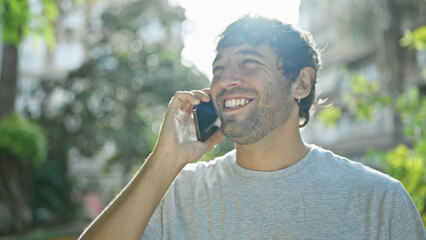 Handsome, young guy, charming with a confident smile, enjoying a funny talk on his smartphone....