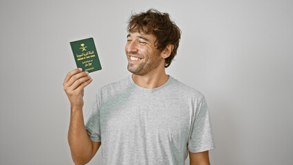 Cheerful young man, holding his saudi arabia passport, beaming with confidence on an isolated white...