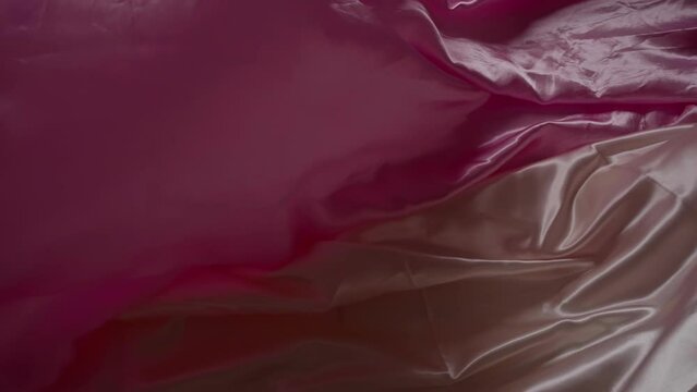 Elegant Satin Fabric in Maroon and Beige Tones. Slowmotion cloth