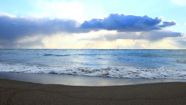 砂浜に打ち寄せる海の波　青空