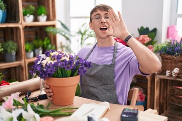 Caucasian blond man working at florist shop shouting and screaming loud to side with hand on mouth....