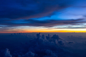 Fototapeta na wymiar Dark heavy thunderstorm cumulus clouds in the morning at dawn, cloudscape view from an airplane