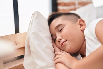 Adorable hispanic boy lying on bed sleeping at bedroom