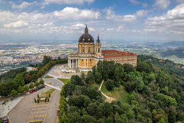 Fototapeta na wymiar The drone aerial view of the famous white orange Basilica of Superga, Turin.The cathedral church located at the top of hill in italian Alps mountains. Turin, Piedmont, Italy.