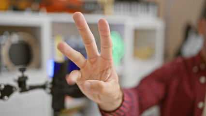 In the heartbeat of the mic, young hispanic man nails live radio show with a thrilling countdown, his three fingers showing time ticking in the upbeat radio studio - obrazy, fototapety, plakaty