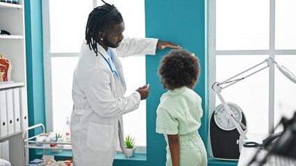 Doctor and patient having medical consultation measuring height at the clinic