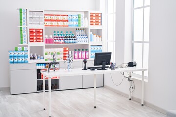 Modern pharmacy interior with medicine shelves, computer, eyeglasses, and counter under bright lighting