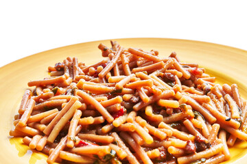 Close-up of a traditional italian pasta e fagioli dish on a yellow plate isolated on a white background.
